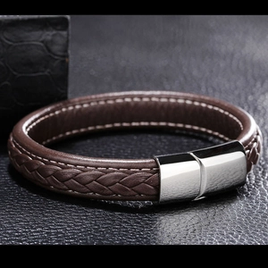 Close-up of brown braided leather bracelet featuring a silver magnetic clasp for men