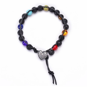 Detail of lava rock beads bracelet with colorful natural stones and silver heart charm