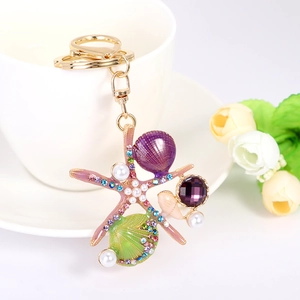 Porte-clés océan doré avec étoile de mer, coquillage et cristal violet sur une tasse