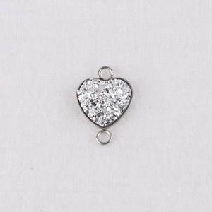 Macro detail of a 13mm heart-shaped stainless steel connector with silver glitter inlay
