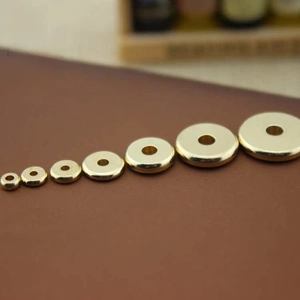 Detailed macro shot of various sizes of polished brass donut beads for DIY jewelry making
