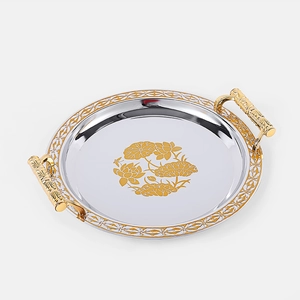 Detail of silver serving tray with golden lotus patterns and elegant side handles