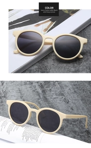 Detail view of vintage round sunglasses with ivory frames and dark lenses on a magazine