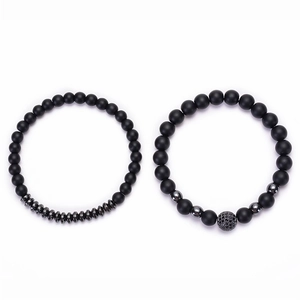 Detail view of two black matte stone couple bracelets with micro-pave zircon ball accents