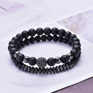 Close-up of matte black bead bracelets with micro-pave zircon ball and metal spacer details