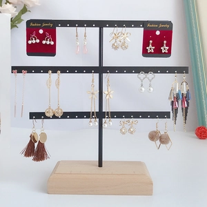 Three-layer black metal earring holder with a solid wooden base for jewelry display