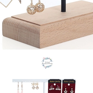 Close-up of wooden earring organizers displaying pearl studs and butterfly drop earrings