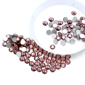 Detailed view of rose gold round flatback crystals with faceted surface and gray coating
