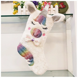 Détail d'une chaussette de Noël licorne en peluche avec crinière arc-en-ciel et corne