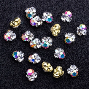Macro shot of three-circle mickey-shaped alloy nail rhinestones in AB, clear, and gold colors
