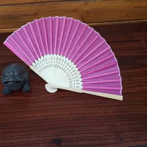 Rose pink folding fan with hollow bamboo ribs and a matching organza drawstring pouch