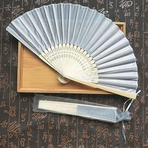 Detail of a Chinese style folding fan with matching sheer organza drawstring gift bag
