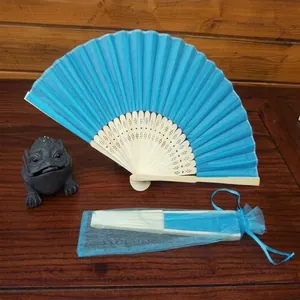 Deep blue folding fan with wooden ribs and a matching organza drawstring storage pouch