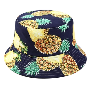 Close-up of navy blue bucket hat with yellow pineapple print and fine stitching details