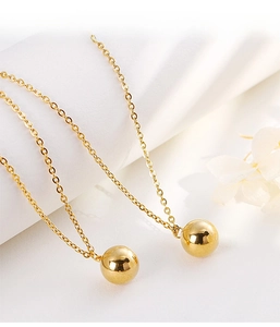 Macro shot of 18K gold plated stainless steel necklaces with polished metal beads