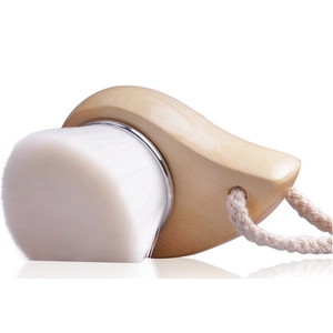 Detail of wooden facial cleansing brush with soft white bristles and woven cotton lanyard