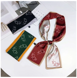 Flat lay of three narrow twilly silk scarves with modern abstract portrait patterns