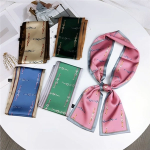Detail of five silk-like scarves featuring golden horsebit patterns in various elegant colors