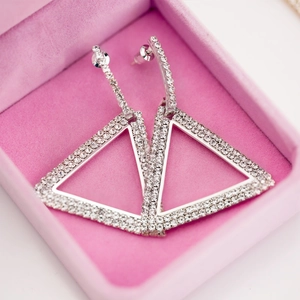 Elegantes pendientes de triángulo geométrico con cristales en un estuche de rosa