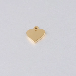 Detailed close-up of a polished gold heart pendant with a small connector ring for DIY