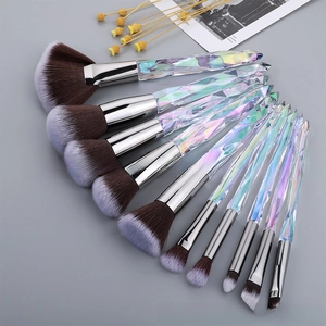 Detail of 10-piece crystal handle makeup brushes with brown gradient bristles on dark background