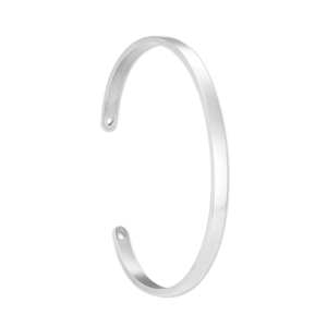 Detalle de brazalete abierto de acero inoxidable plateado con corte de corazón