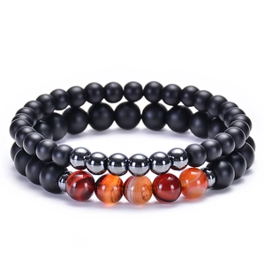 Détail de bracelets en perles d'onyx mat et d'agate rayée avec cordon élastique
