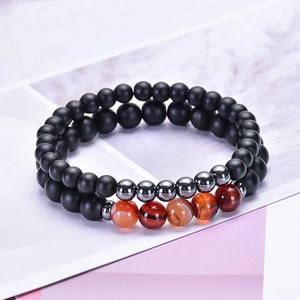 Gros plan de perles d'onyx noir mat et d'agate rayée sur un bracelet à double épaisseur