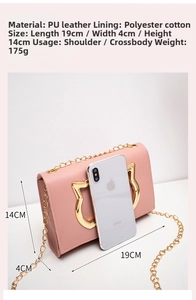 Pink PU crossbody bag featuring a cat-shaped gold buckle and chain strap shown with a phone