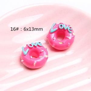 Macro detail of 6x13mm pink resin donuts for DIY crafts with Love engraving