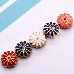 Macro shot of colorful enamel sunflower beads with golden metal edges for DIY jewelry making