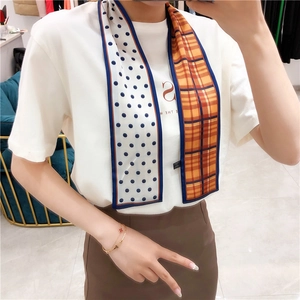 Detailed shot of double-sided skinny scarf with polka dots and plaid patterns