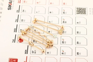 Set of gold industrial barbells with arrow, spiral and crystal designs for ear piercings