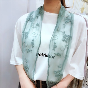 Detailed embroidery on light green mesh lace scarf worn by a model in casual setting