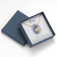 Detailed view of Aries zodiac necklace with gold ram pendant in a premium blue gift box