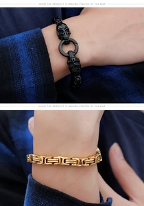 Detail of men's black skull head bracelet and gold Byzantine chain with shirt cuff