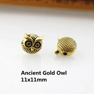 Detailed view of 11x11mm antique gold owl charm beads with intricate relief for DIY jewelry