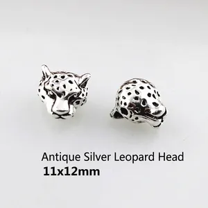 Detail of antique silver leopard head jewelry beads with embossed textures, 11x12mm size
