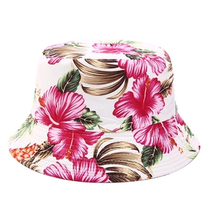 Detail of tropical floral print on bucket hat featuring pink hibiscus and palm leaves