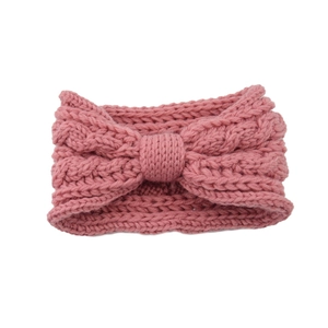 Close-up of pink knitted bow headband showing thick texture and soft weaving detail