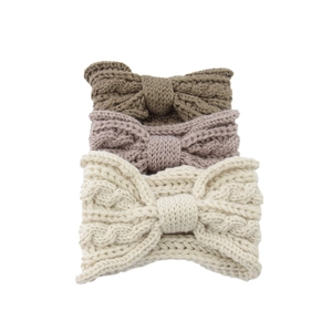 Close-up of wide knit bow headbands in brown, pink, and beige with cable knit texture