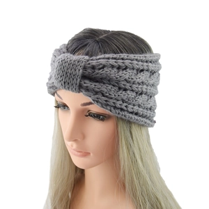 Close-up of grey knit headband featuring a twist knot design and thick cable texture