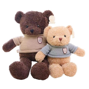 Osos de peluche grandes y pequeños con suéteres de punto y escudos en fondo blanco
