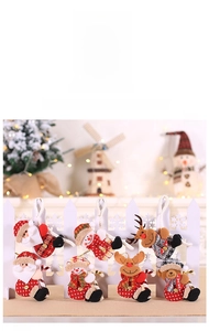 Detail view of plush Christmas ornaments featuring Santa, snowman, elk, and bear hanging on a fence