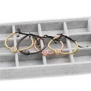Detail of four woven evil eye bracelets with micro-paved zircons on a velvet display