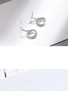 Detailed view of silver double-loop earrings with pave crystals and metal bar accents