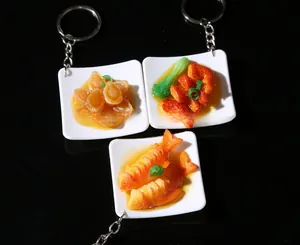 Realistic PVC food keychains featuring braised pork and abalone on a black background