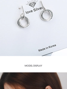 Macro shot of double silver hoops earrings with zircon stones on a display card