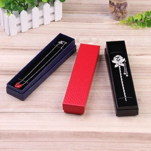 Detailed view of rectangular jewelry boxes in blue, red, and black on a wooden table