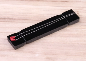 Detail of red swan pendant necklace with crystal inlay on a black sponge display pad